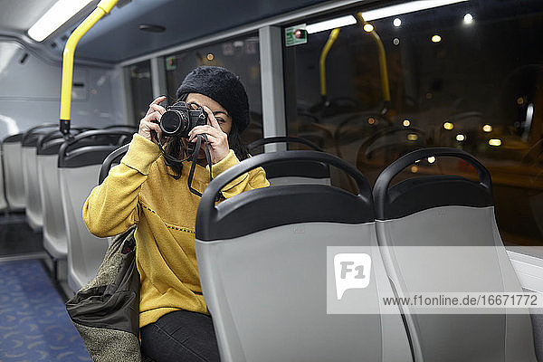 Frau macht Fotos in einem öffentlichen Verkehrsmittel