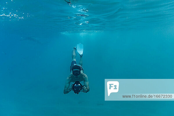 Schnorchler schwimmt beim Fotografieren unter Wasser im hawaiianischen Ozean