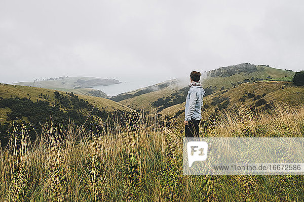 Woman on a blue shirt looking at the scenery  Banks Peninsula  NZ