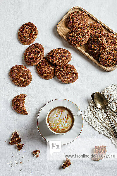 Leckerer Kaffee mit einer Zeichnung aus Sahne und hausgemachten Keksen