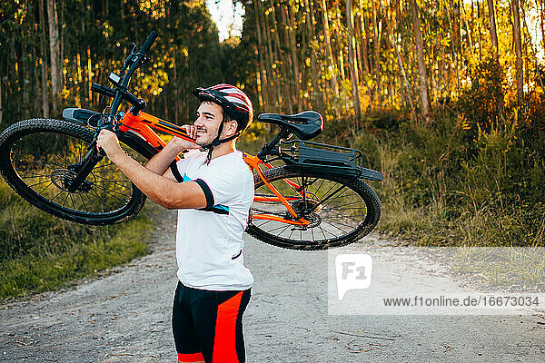 Man carrying bicycle on shoulder