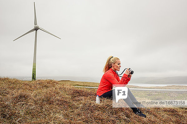 Blonde Frau prüft Fotos auf dem Lande