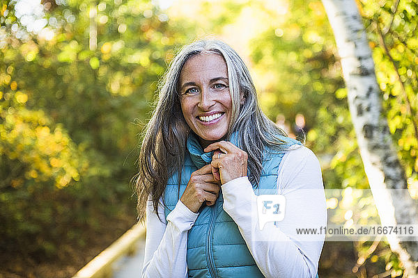 Grauhaarige Frau genießt einen Spaziergang in der Natur