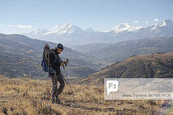 One woman with a backpack hiking around Huaraz with Cordillera Blanca