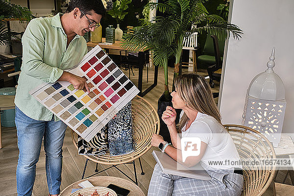 Stoffverkäufer zeigt seinem Kunden die Farbkarte