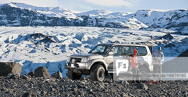 Junges Paar  das sich auf eine Wanderung aus seinem Geländewagen in Island vorbereitet
