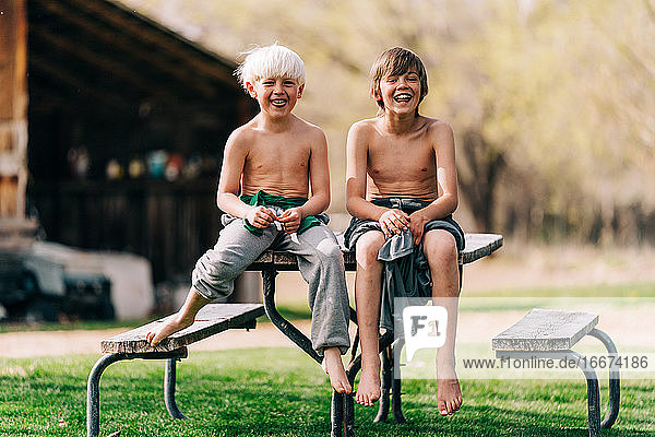 Zwei Kinder sitzen lächelnd am Picknicktisch