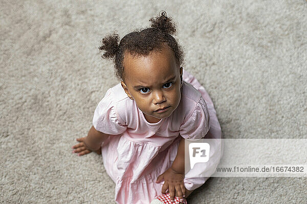 Gemischte Rasse Baby Mädchen schaut intensiv auf