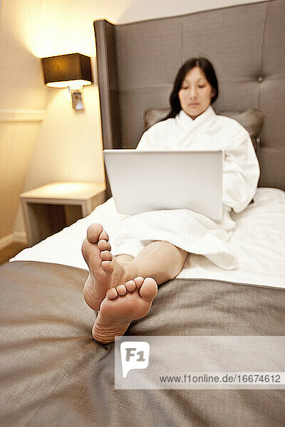 Geschäftsfrau benutzt Laptop im Hotelzimmer