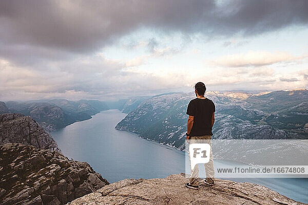 Man standing at edge of cliff at Preikestolen  Norway