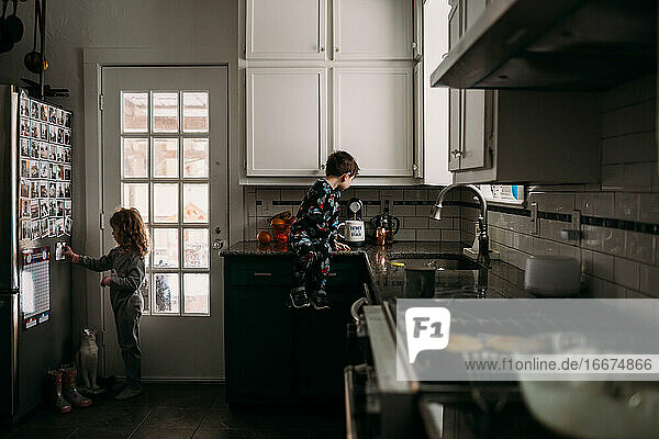 Young boy and girl helping in kitchen during breakfast time