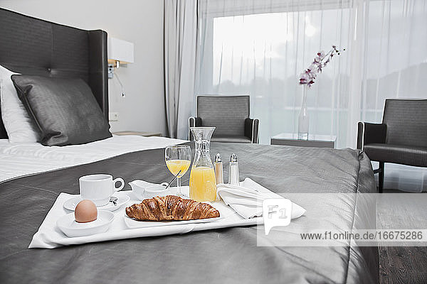 Frühstückstablett auf einem Bett in einem Luxushotelzimmer