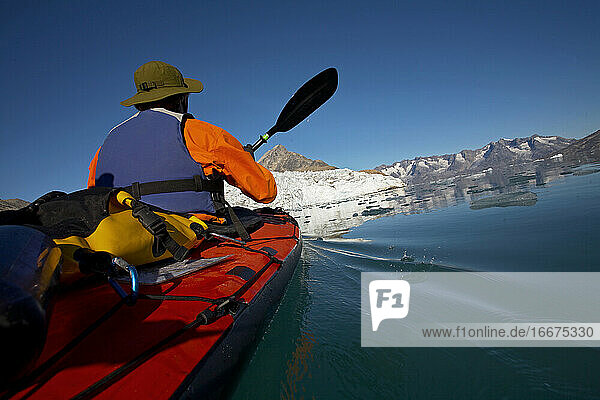Mann  der in einem Seekajak durch die Fjorde Ostgrönlands fährt