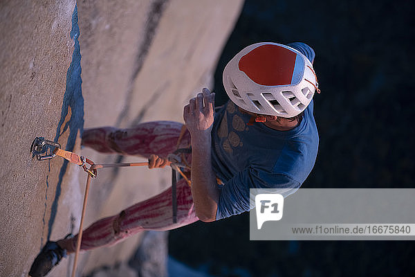 Bergsteiger mit Helm  der an der Wand hängt  während er die schwierige Route El Capitan versucht