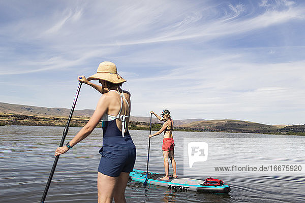 Two female friends on their SUPs on the Columbia River in Oregon.