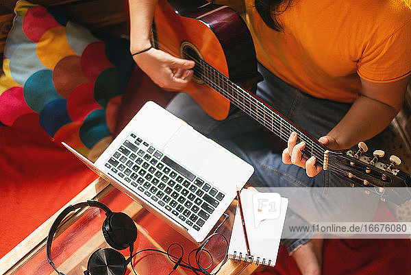 Person  die einen Online-Gitarrenkurs auf ihrem Computer besucht  neue Normalität