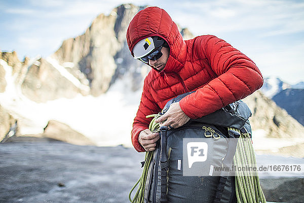 Mountaineer packing his backpack after a successful climb.