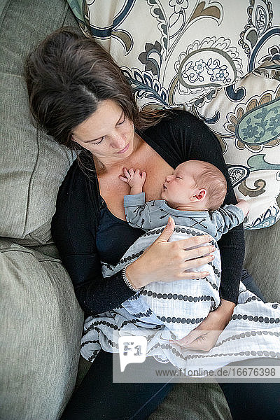 Ein neugeborenes Baby schläft mit seiner liebevollen Mutter.
