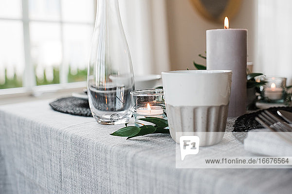 Wasserglas und Kerze auf einem romantischen Tisch für zwei Personen