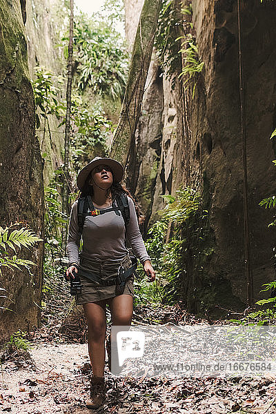 Junge Frau erkundet einen Canyon mit Action-Kamera und GPS.