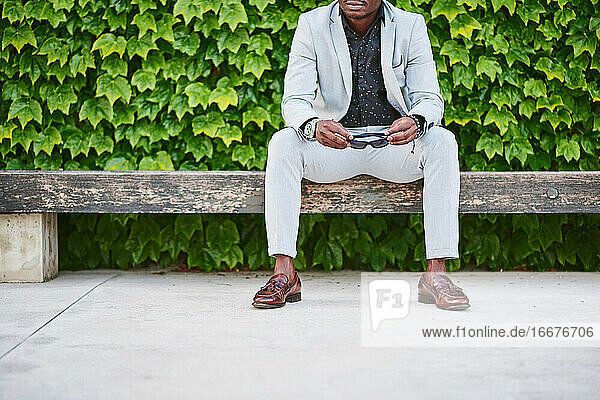 Afroamerikanischer Mann sitzt auf einer Parkbank