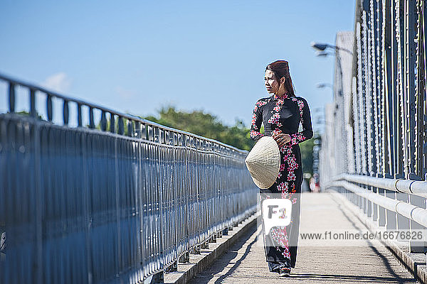 schöne Frau beim Spaziergang über die Truong-Tien-Brücke in Hue / Vietnam