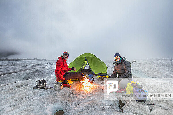 Teo-Bergsteiger genießt das Lagerfeuer beim Zelten auf einem Gletscher.