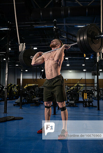 Male athlete with barbell during training in gym