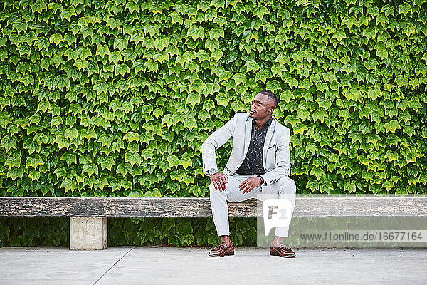 Afroamerikanischer Mann sitzt auf einer Parkbank