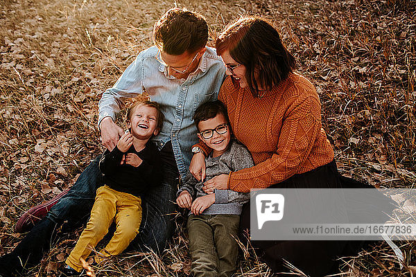 Happy young family sitting together on a fall evening