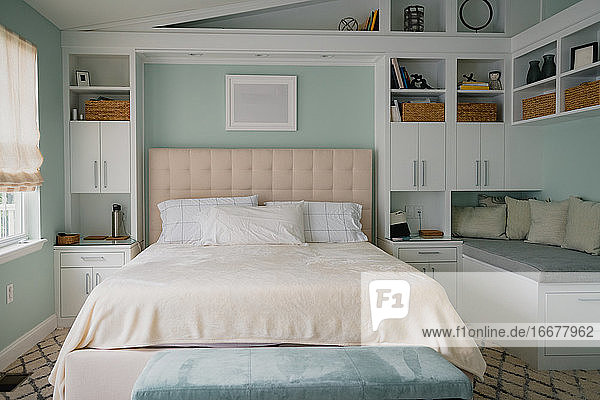 bright bedroom interior with built in bookshelves and bench