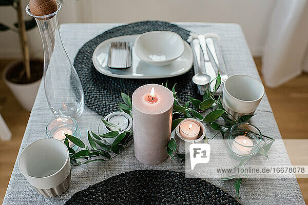 große Kerze auf einem romantisch gedeckten Tisch zu Hause für zwei Personen