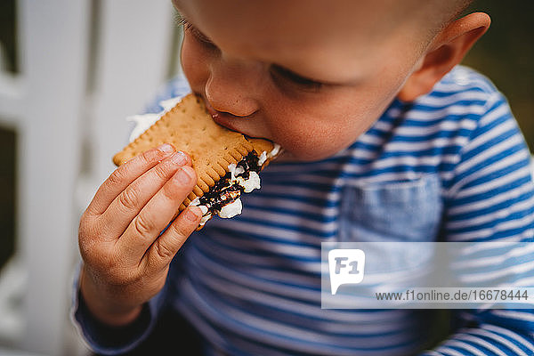 Nahaufnahme eines kleinen Jungen  der Kekse und Marshmallows isst