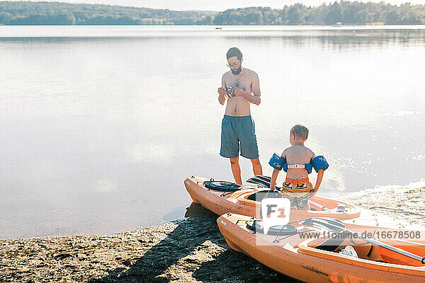 Ein Vater und sein Sohn bereiten sich auf ihre Kajaktour auf dem See vor