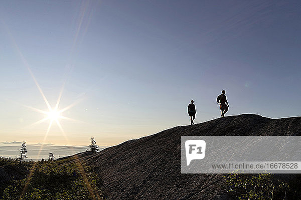 Paar wandert bei Sonnenaufgang auf Berggipfel Appalachian Trail Maine