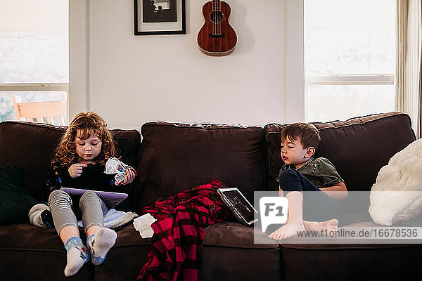 Young sister and brother home sick from school with flu
