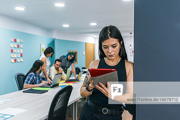 Eine Geschäftsfrau benutzt ein Tablet in einem Coworking-Büro