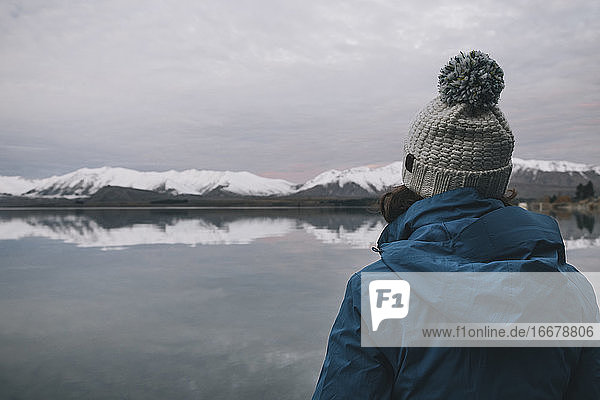 Junge Frau in blauer Jacke starrt auf den Lake Tekapo  Südalpen