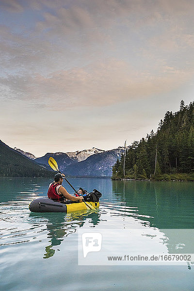 Vater paddelt mit seinem Sohn auf einem malerischen See in Kanada.