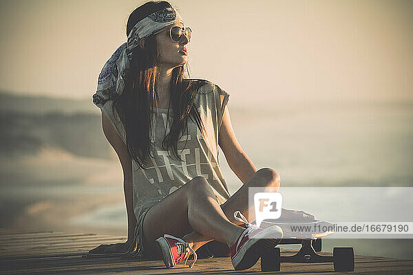 Schönes junges Mädchen mit ihrem Skateboard