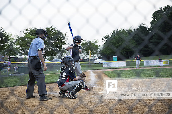 Breite Rückansicht von Teenager-Junge am Schläger während Baseball-Spiel