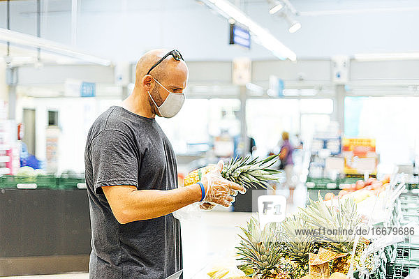 Mann kauft frisches Obst im Supermarkt