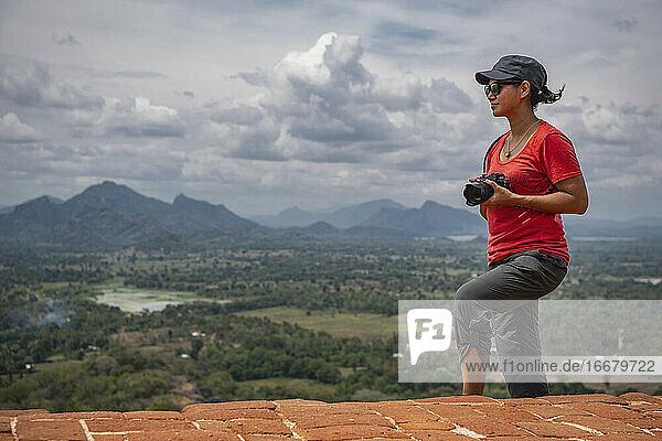 Woman taking picture on the top of the rock fortress of Sigiriya