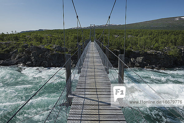 Hängebrücke über das fließende Wasser des Flusses Vuojatädno entlang des Padjelantaleden-Pfades  Lappland  Schweden