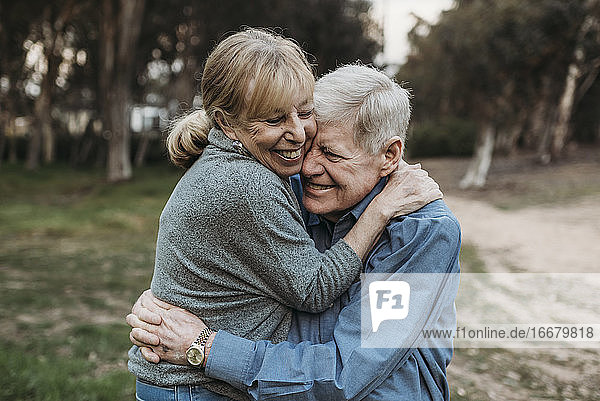 Close up portrait of senior adult couple embracing in forest