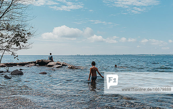 Kinder waten und schwimmen an einem heißen Sommertag im Ontariosee.