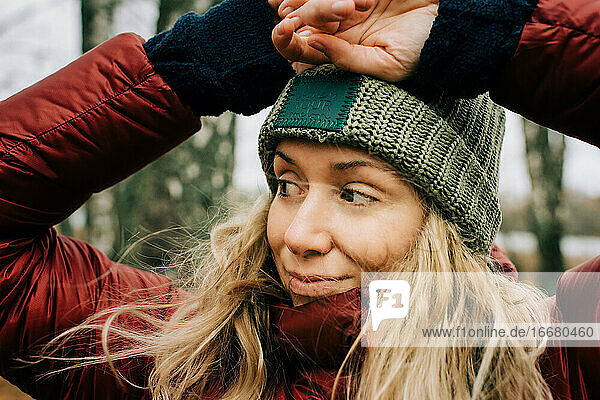 Porträt einer lächelnden Frau  die im windigen Wald in Schweden steht