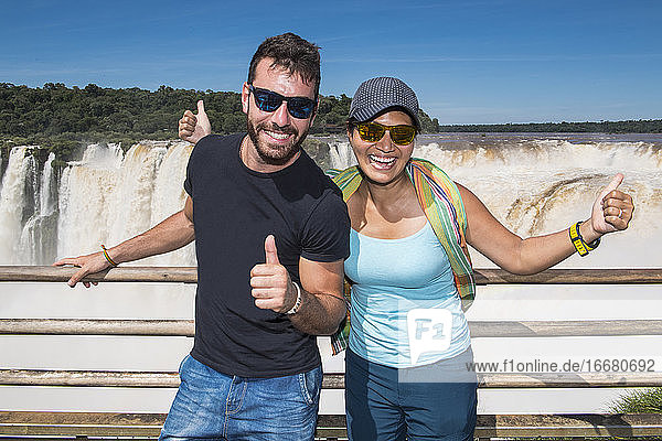couple posing at the Devil's Throat waterfall at Iguazu Falls