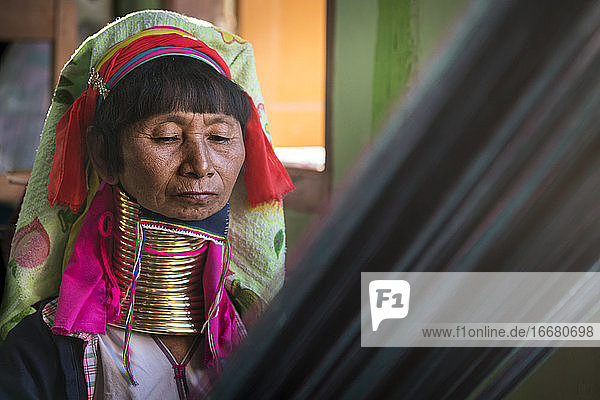 Porträt einer älteren birmanischen Frau vom Stamm der Kayan beim Weben in einer Textilwerkstatt  Inle-See  Myanmar