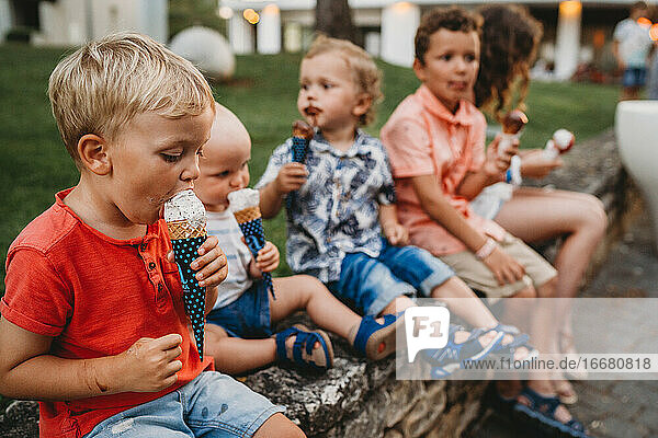 Young kids of a family eating ice cream getting dirty and messy